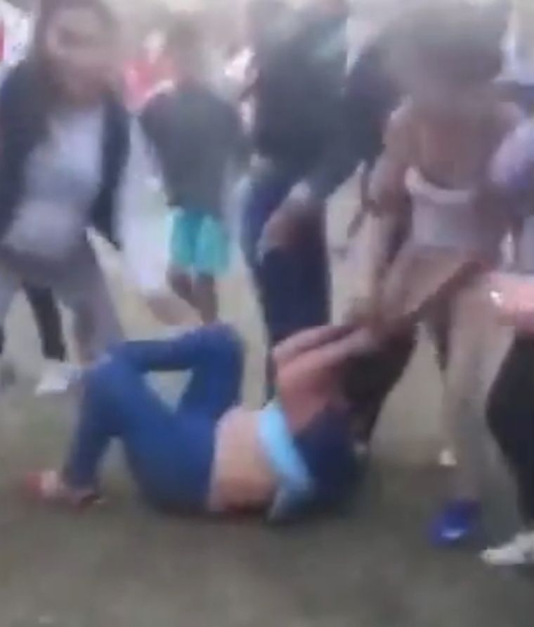 Una mujer cae al piso, pero le siguen pegando