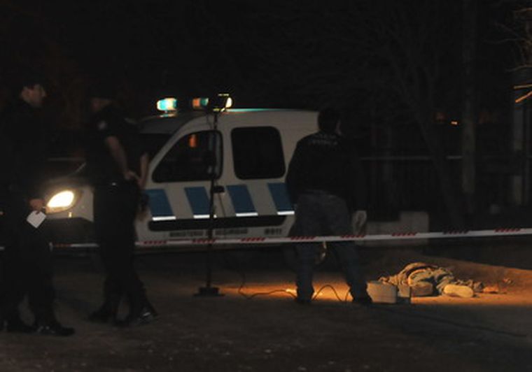 Efectivos observan el cadáver en el suelo.