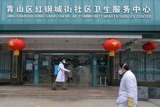 Un médico desinfecta la entrada de un centro de servicios de salud comunitario en el distrito Qingshan de Wuhan, China, el 2 de febrero de 2020.
