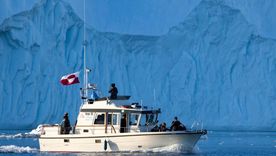 Un barco con la bandera de Groenlandia. Un barco con la bandera de Groenlandia.