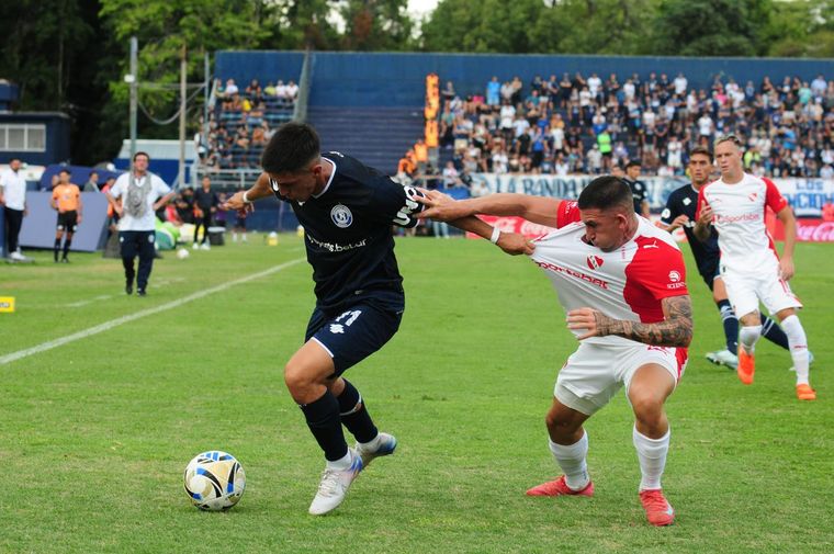 Gonzalo Ríos aguanta la pelota mientras camisetea al defensor del Rojo que lo marca.&nbsp;&nbsp;