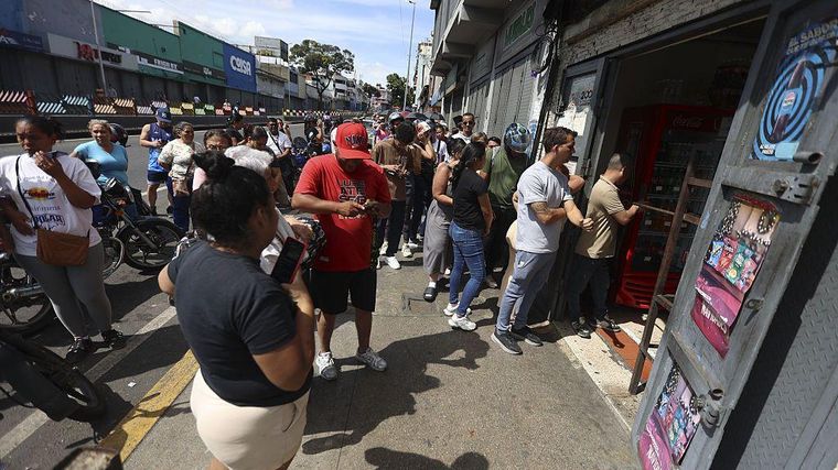 Gente esperando afuera de un supermercado en Caracas.