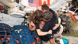 Los astronautas del Artemis II fundidos en un abrazo dentro de la nave Orion.