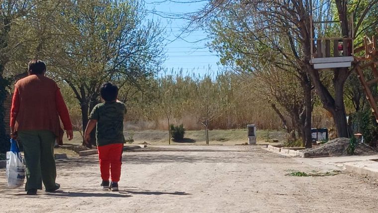 Una vecina con su nieto caminan en el barrio Jardín El Sauce. En el horizonte el cañaveral que esconde al Pescara, un curso de agua muerto. Una vecina con su nieto caminan en el barrio Jardín El Sauce. En el horizonte el cañaveral que esconde al Pescara, un curso de agua muerto.