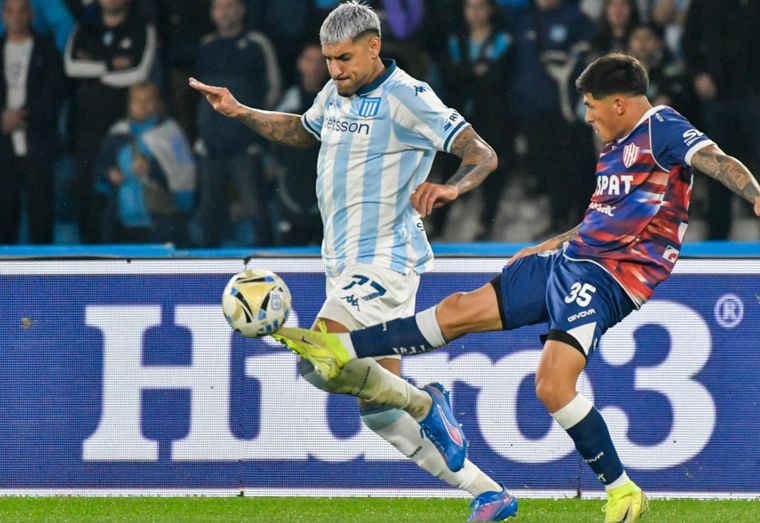 Adrián Balboa, delantero de Racing, se lleva el balón ante la marca de Lautaro Vargas.&nbsp;