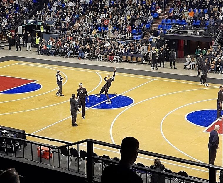 Uno de los integrantes del equipo intentando encestar desde la mitad de la cancha.