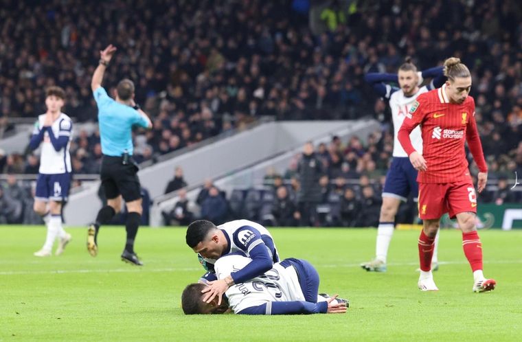 Pedro Porro, del Tottenham, atiende a su compañero Rodrigo Bentancur mientras yace tendido en el suelo durante el partido de semifinales de la Copa de la Liga inglesa. Foto: EFE