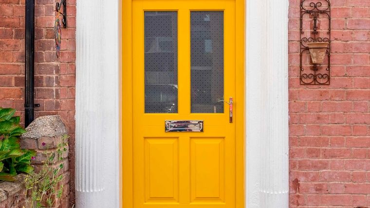 Puerta pintada de amarillo vibrante. Foto: Instagram timberwindows