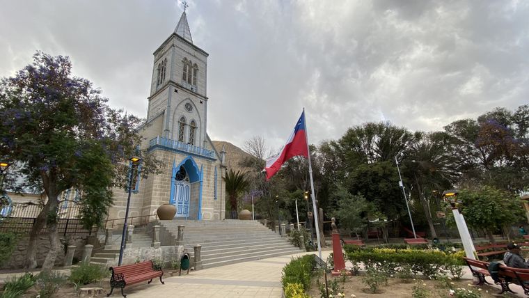 La iglesia de Pisco Elqui, uno de los puntos más emblemáticos del pueblo, rodeada de árboles y con la cordillera de fondo.