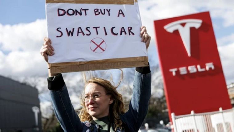 Una mujer protesta contra Tesla y Elon Musk en Reino Unido. Foto: BBC