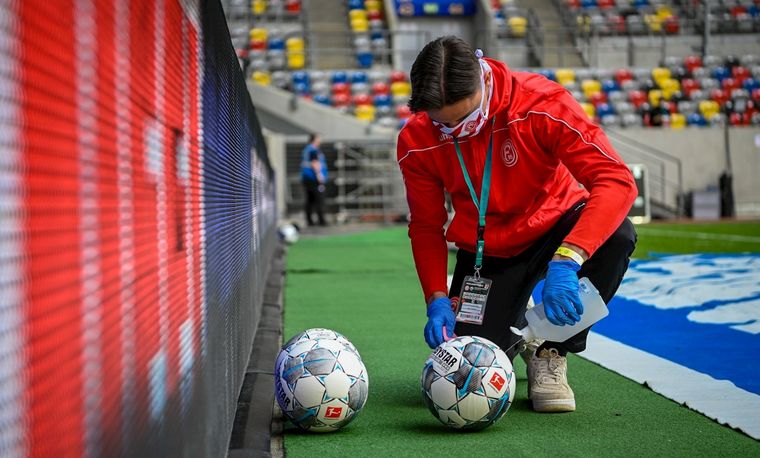 Una pelota es desinfectada durante el partido entre el Fortuna Dusseldorf y el Paderborn. EFE Foto: EFE