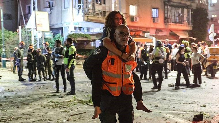 Rescatistas trasladan a civiles tras un ataque iraní cerca de Tel Aviv.