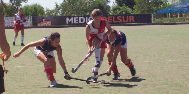 La delantera de San Jorge penetrando entre dos rivales.