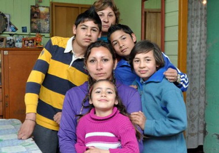 La niña con su madre y sus hermanos.