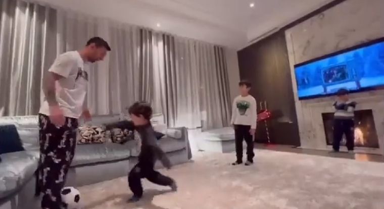 Leo junto a sus hijos en el living de casa