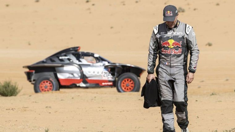 Peterhansel camina por la arena y el Audi se ve a lo lejos. Foto: @dakar