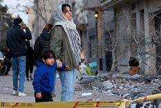 Una mujer y su hijo observan las consecuencias de un ataque aéreo estadounidense-israelí contra una comisaría de policía en Teherán a principios de marzo.