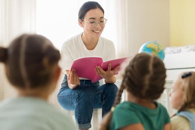 MDZol | mujer-de-vista-frontal-leyendo-algo-para-sus-estudiantes