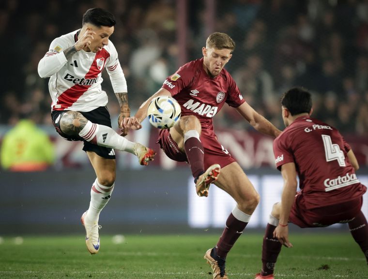 El Granadero Castillo, autor del agónico empate de Lanús, disputa el balón con Sebastián Dirussi, quien ingresó en el ST por Colidio.
