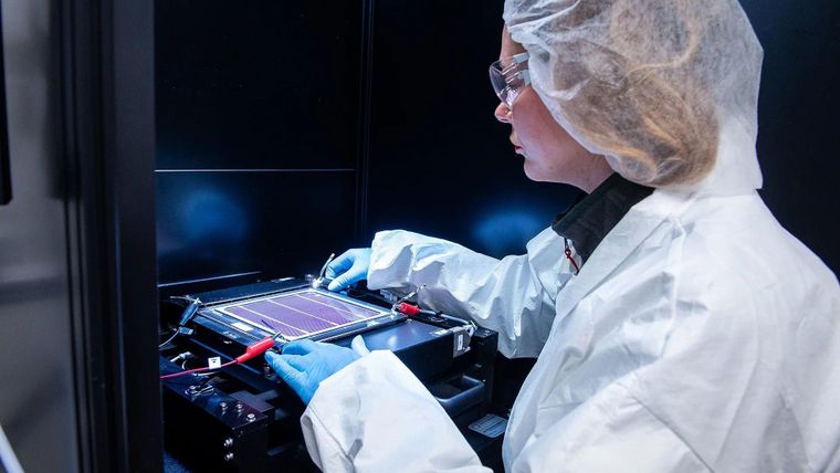 En las instalaciones alemanas de Oxford PV, una investigadora se prepara para tomar una medición de una célula solar en tándem.