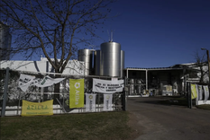 La entrada a Lácteos Vidal con banderas de Atilra, el gremio lechero que paralizó a la planta.