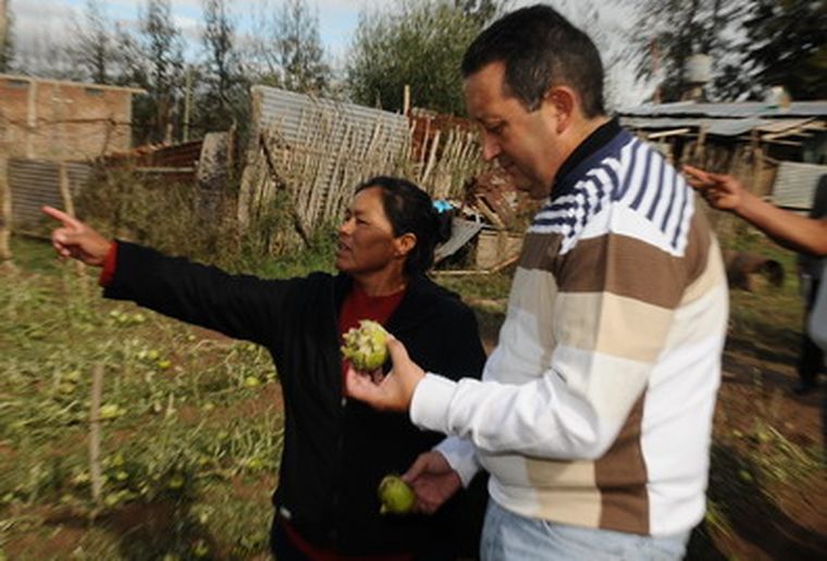 Jaque junto a una mujer que le señala los daños.