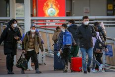 Viajeros en el Aeropuerto Internacional de Pekín, en China, que ha reabierto hoy sus fronteras tras casi tres años de cierre.  Foto: EFE/EPA/MARK R. CRISTINO