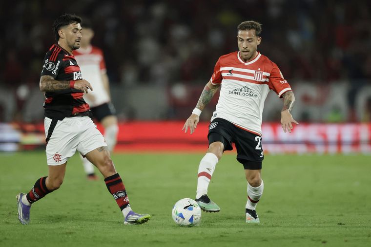 Ezequiel Piovi defiende la pelota ante De Arrascaeta en Flamengo-Estudiantes.