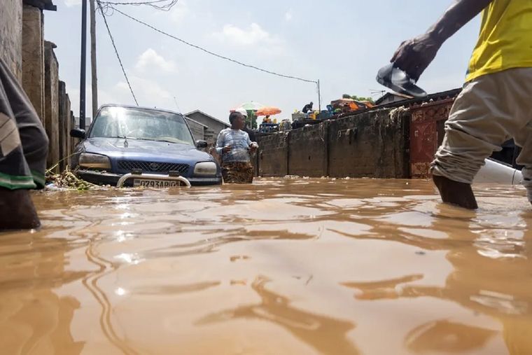 Residentes locales caminan por una calle inundada en Kinshasa, República Democrática del Congo. Foto: EFE