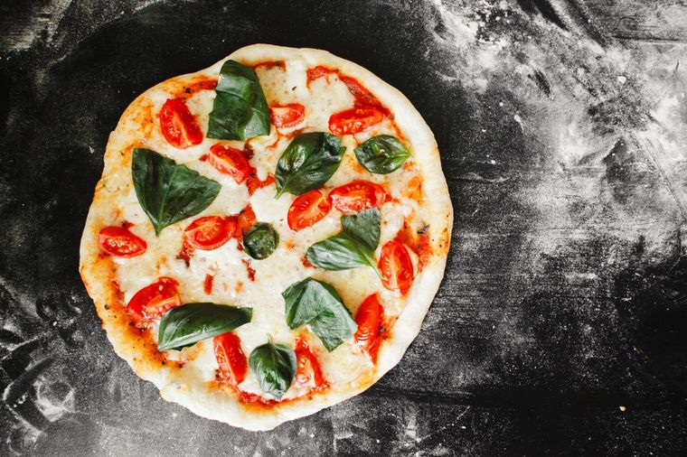 Preparar pizza a la piedra para recibir amigos o familia en casa es un plan espectacular. Foto: Unsplash
