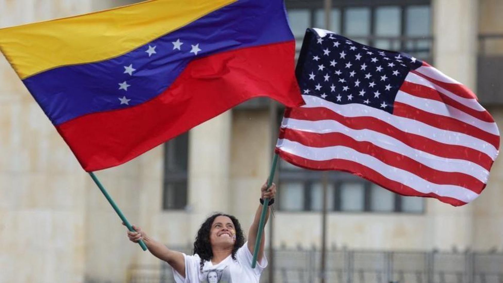 Una mujer ondea las banderas de EE.UU. y Venezuela.