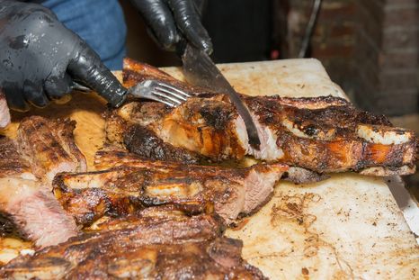 El asado banderita se caracteriza por sus tiras delgadas, el corte transversal del hueso y una cocción rápida sobre las brasas.