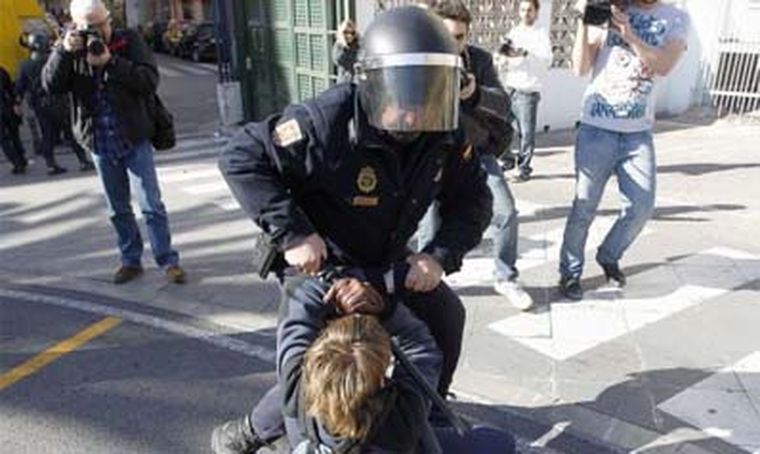 Un policía sujeta a un estudiante.