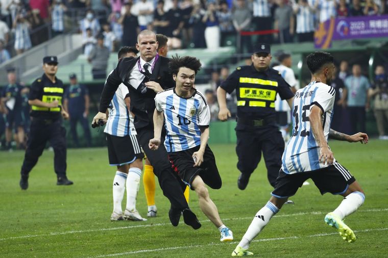 El hincha ya abrazó a Messi y se escapa de la seguridad. Foto: EFE