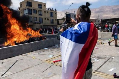 MDZol | Un ciudadano toma una imagen de la quema de ropa y pertenencias de los migrantes que han llegado a Iquique en los últimos meses. Foto: GETTY IMAGES
