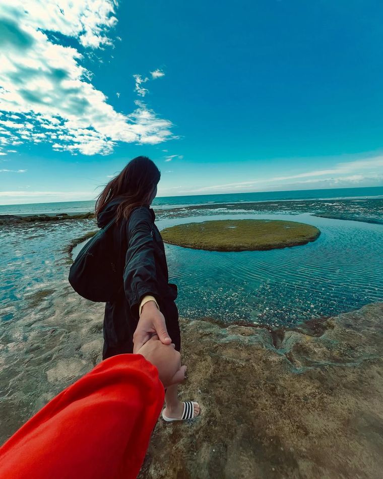 La feliz pareja en una postal soñada: junto al mar y enamoradas.