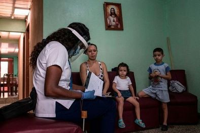 MDZol | Una trabajadora del sector de la salud le daba información, en julio de 2020, a una familia sobre la prueba de detección de covid-19, en su hogar. Foto: EZEQUIEL BECERRA/AFP VIA GETTY IMAGES