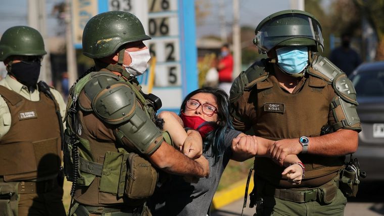 Una mujer es detenida después de gritar consignas contra la policía antidisturbios en un barrio pobre de la comuna El Bosque, en Santiago, Chile.