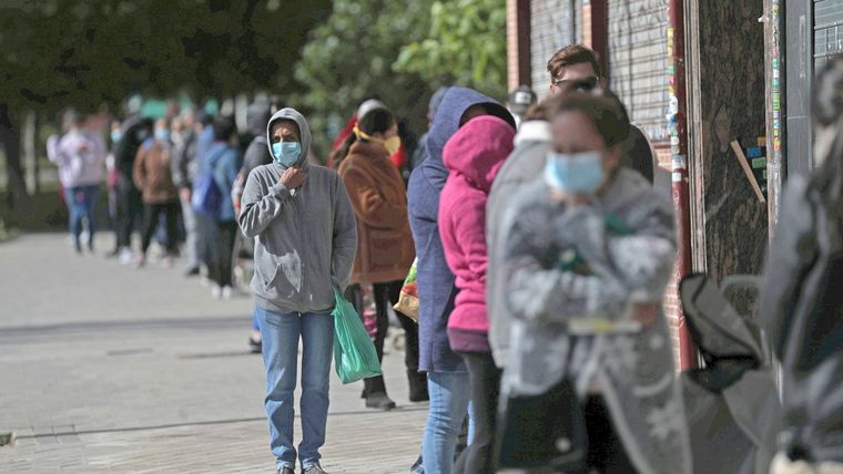 Cola de personas para recibir alimentos donados de voluntarios de la asociación de Vecinos Parque Aluche. Madrid, 16 mayo 2020.