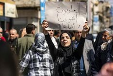 Una mujer sostiene un cartel que dice en árabe Los alauitas son nuestros hermanos y familia durante una manifestación multitudinaria en la ciudad de Qamishli, en el noreste de Siria. Foto: BBC