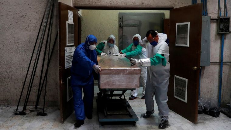 Empleados de una funeraria trasladan el ataúd de una víctima de covid-19 en un crematorio de México, el 21 de mayo de 2020.