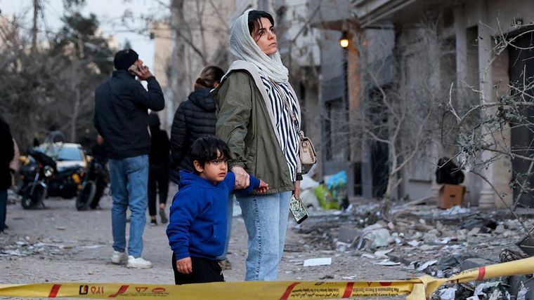 Una mujer y su hijo observan las consecuencias de un ataque aéreo estadounidense-israelí contra una comisaría de policía en Teherán a principios de marzo.