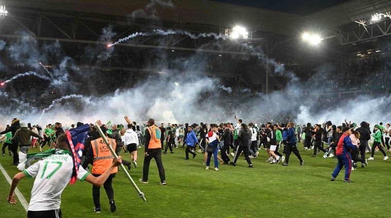 Los hinchas dentro del campo. Foto: EFE