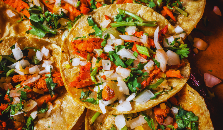 La carne de estos deliciosos tacos se cocina en un trompo vertical, igual que el kebab o el shawarma, y se corta en finas láminas ¿lo sabías?