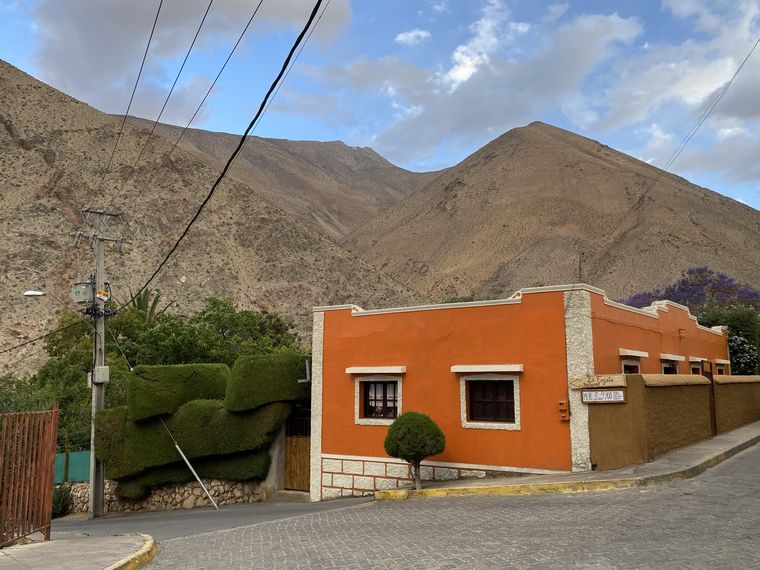 Las casas naranjas y sus jardines recortan el paisaje del Valle de Elqui, con la montaña imponente a pocos metros. Las casas naranjas y sus jardines recortan el paisaje del Valle de Elqui, con la montaña imponente a pocos metros.