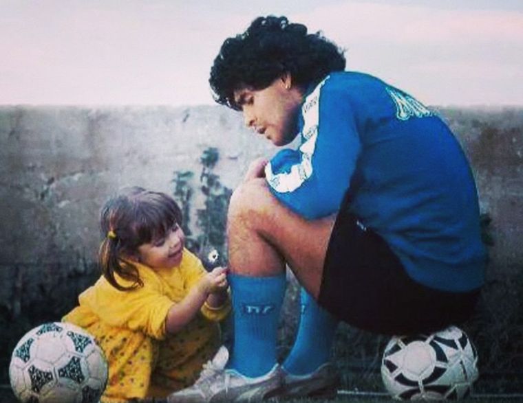 Una de las fotos más icónicas de la infancia de Dalma Maradona cuando le puso margaritas en las medias a Diego. Foto: Archivo MDZ