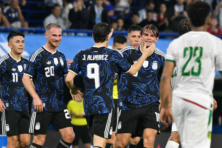 Nico Paz recibe las felicitaciones de sus compañeros tras convertir su gol para la Selección argentina.