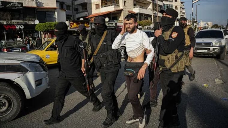 Miembros de las fuerzas de seguridad sirias detienen a un hombre sospechoso de apoyar al antiguo régimen de Bashar al Assad en Latakia este sábado. Foto: BBC