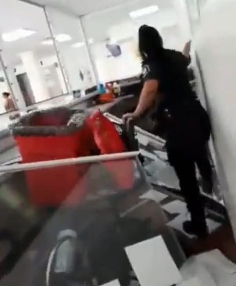 Una oficial de policía camina entre los destrozos.