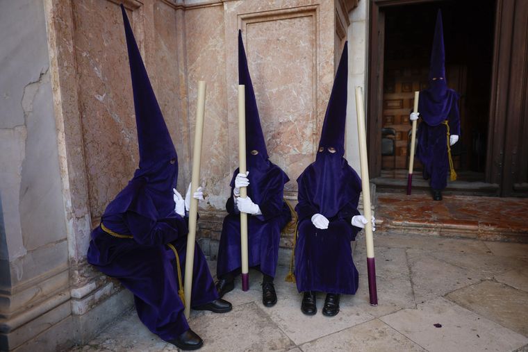 Penitentes descansan con su uniforme en Málaga. Penitentes descansan con su uniforme en Málaga.